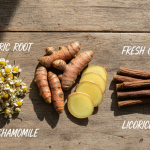 Flat lay of turmeric root, ginger slices, chamomile flowers, and licorice sticks, shown as natural remedies for reflux.